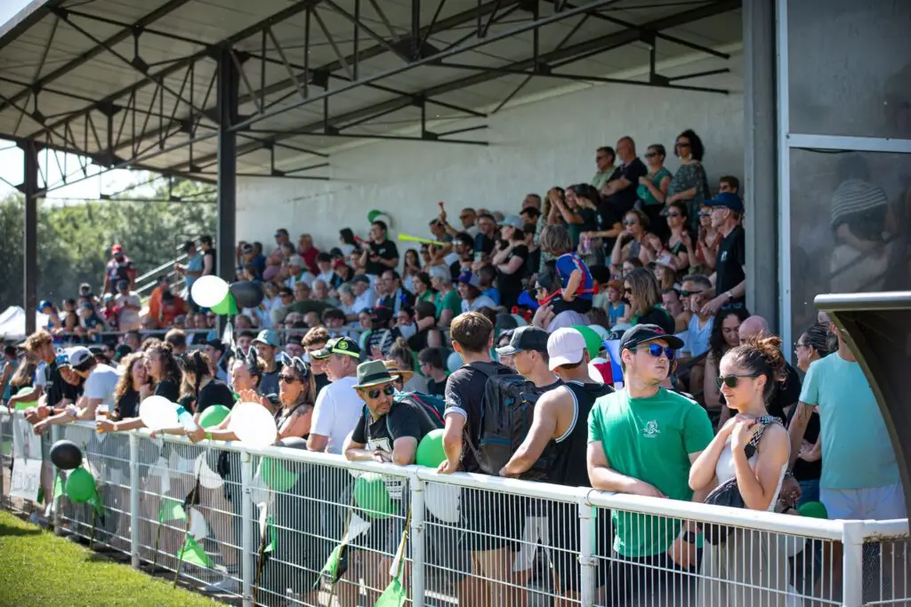 Público masificado en la tribuna y a lo largo de la valla del estadio de Auch, con globos verdes y blancos en los colores del club