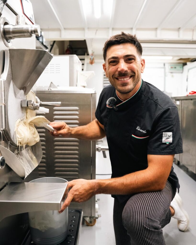 Edoardo Gori con uniforme de heladero, espátula en mano, delante de la máquina de helado de su laboratorio Ughissimo en Bayona