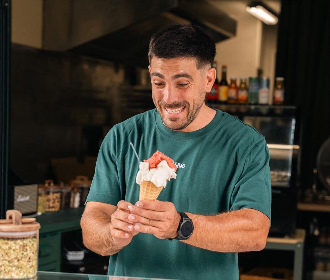 Edoardo Gori, souriant, tend un cornet de glace italienne derrière le comptoir de sa gelateria Ughissimo à Bayonne