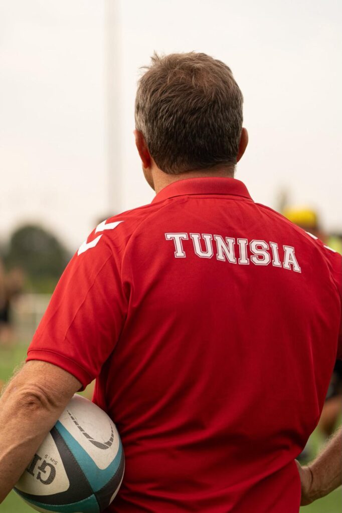 Christophe Hamacek de espaldas, con el balón bajo el brazo, y un polo rojo con la inscripción Tunisia